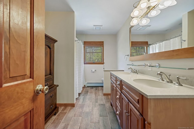 4 Walnut Ridge Rd, New Fairfield, CT 06812 - full bathroom featuring toilet, a baseboard heating unit, a sink, and wood finished floors