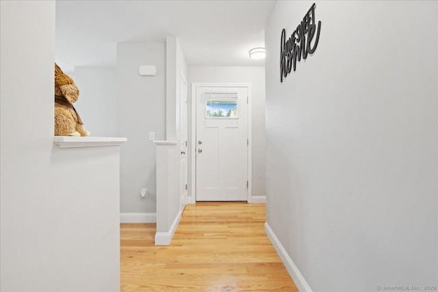 hall with baseboards and light wood-type flooring
