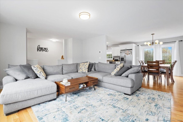 living area with a notable chandelier and light wood-style floors
