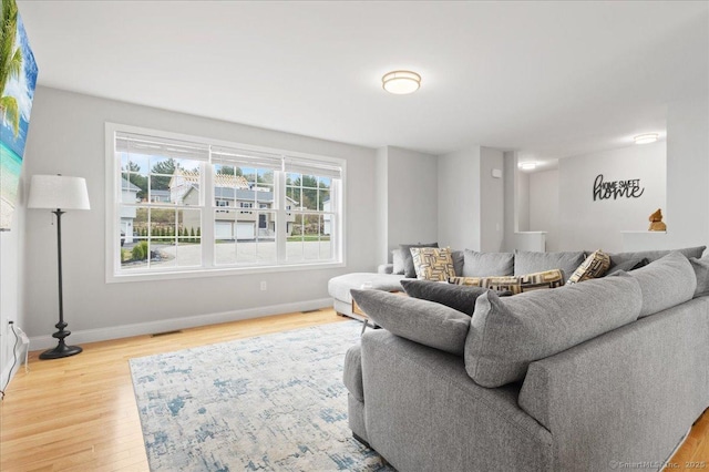 living room with visible vents, wood finished floors, and baseboards