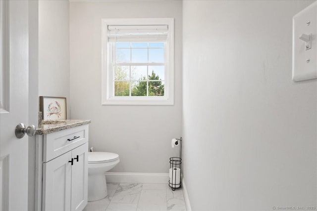 bathroom featuring baseboards, marble finish floor, vanity, and toilet