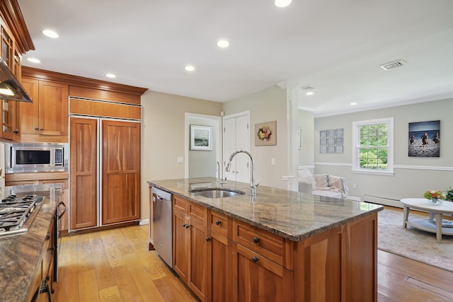 50 Carriage Dr S, Stamford, CT 06902 - kitchen featuring built in appliances, a sink, brown cabinets, dark stone countertops, and light wood-type flooring