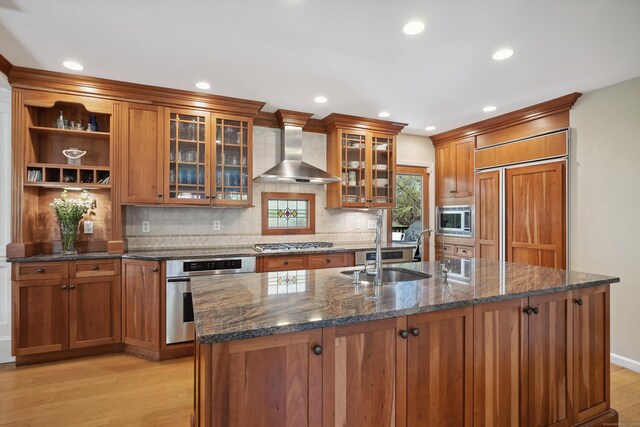 50 Carriage Dr S, Stamford, CT 06902 - kitchen with built in appliances, wall chimney range hood, light wood finished floors, tasteful backsplash, and brown cabinetry