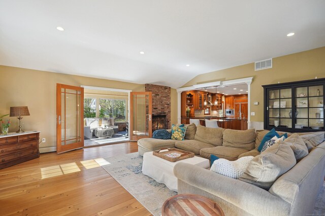 50 Carriage Dr S, Stamford, CT 06902 - living room with light wood-type flooring, a baseboard heating unit, vaulted ceiling, french doors, and recessed lighting