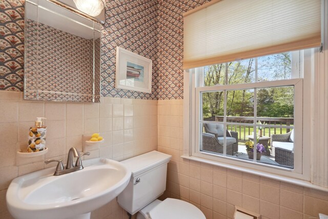 50 Carriage Dr S, Stamford, CT 06902 - half bathroom with a sink, wallpapered walls, toilet, and tile walls