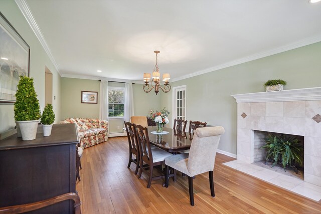 50 Carriage Dr S, Stamford, CT 06902 - dining space featuring a chandelier, light wood-style flooring, a baseboard radiator, crown molding, and baseboards
