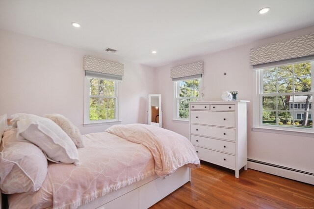 50 Carriage Dr S, Stamford, CT 06902 - bedroom featuring multiple windows, wood finished floors, recessed lighting, and baseboard heating