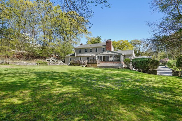 50 Carriage Dr S, Stamford, CT 06902 - back of house featuring a chimney, a wooden deck, and a lawn