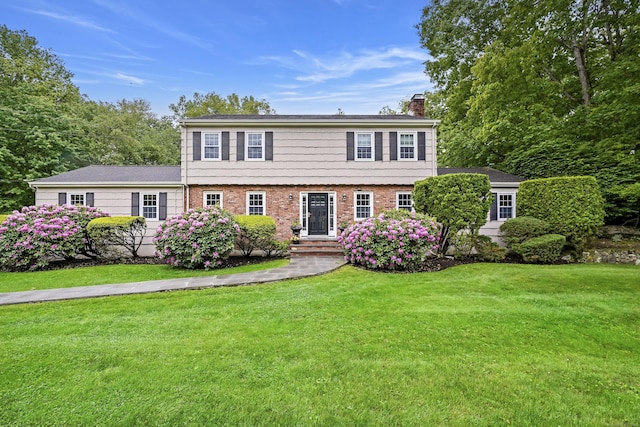 50 Carriage Dr S, Stamford, CT 06902 - colonial-style house with a chimney, a front yard, and brick siding