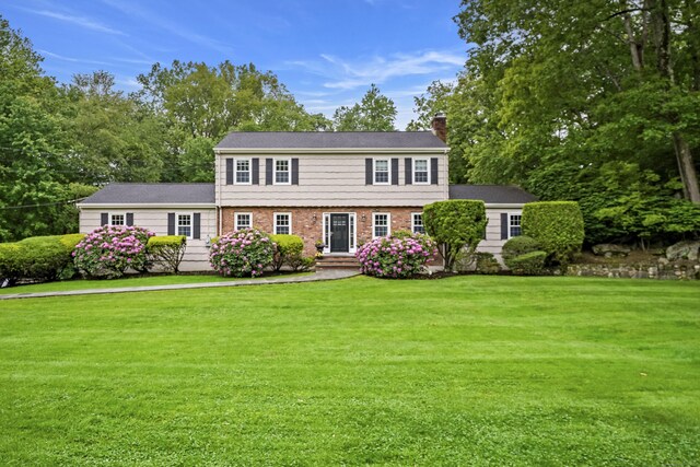 50 Carriage Dr S, Stamford, CT 06902 - colonial house featuring a chimney, a front lawn, and brick siding