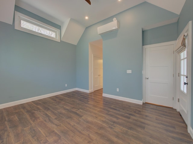 spare room featuring dark wood-style flooring, a wall mounted air conditioner, recessed lighting, baseboards, and lofted ceiling