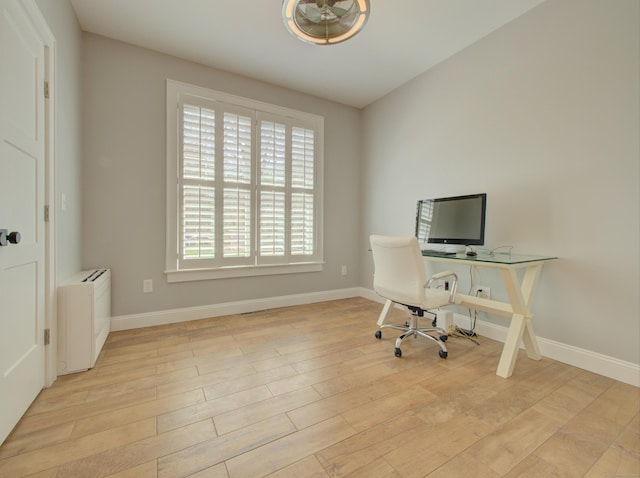 office space featuring baseboards and light wood finished floors