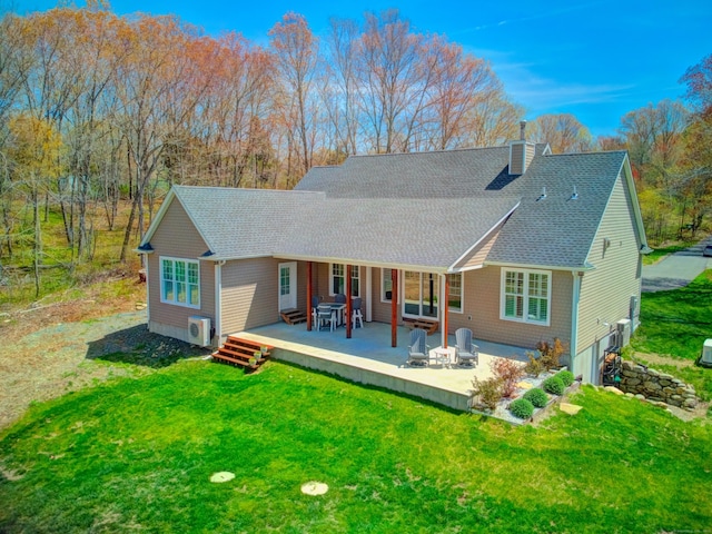 rear view of property featuring a lawn, roof with shingles, a wooden deck, and a chimney