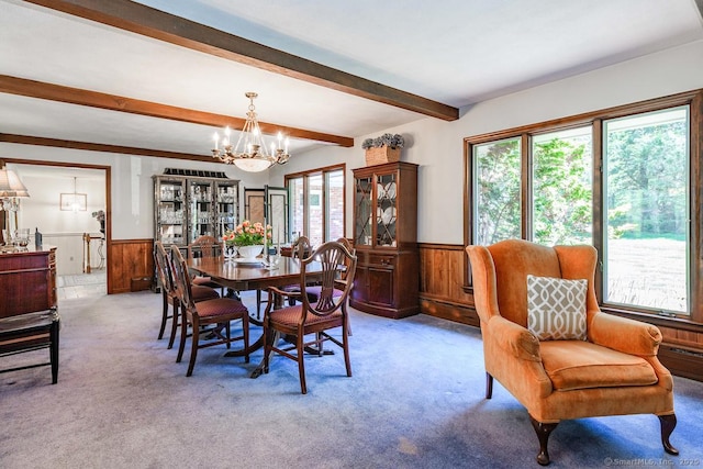 dining area featuring an inviting chandelier, wainscoting, wooden walls, and beamed ceiling