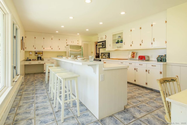 kitchen with a center island, light countertops, stainless steel appliances, recessed lighting, and white cabinetry