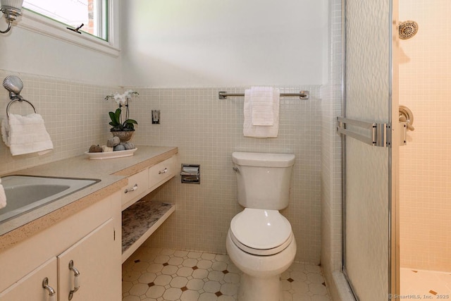 bathroom with tile walls, a stall shower, vanity, a wainscoted wall, and toilet