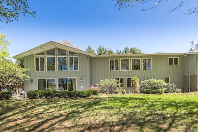 rear view of property with a yard and board and batten siding