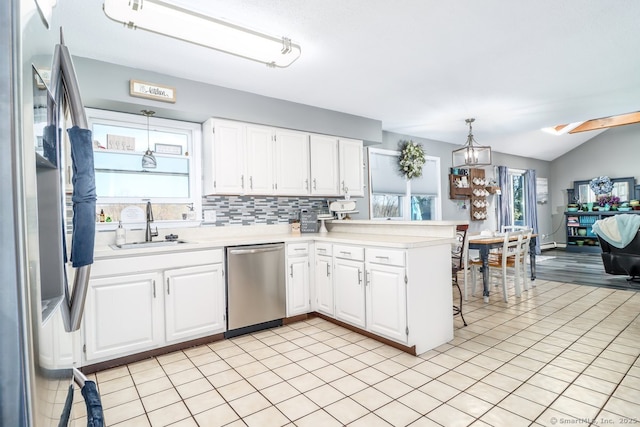 kitchen with light countertops, a sink, appliances with stainless steel finishes, and a healthy amount of sunlight