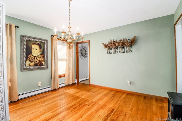 unfurnished dining area featuring an inviting chandelier, baseboards, light wood-style floors, and a baseboard heating unit