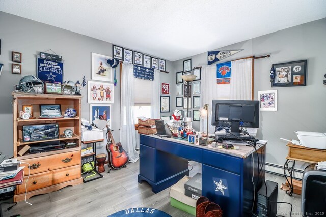 office with light wood finished floors and a baseboard radiator