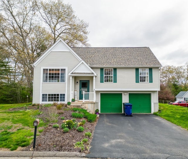 bi-level home with an attached garage, driveway, and a front lawn
