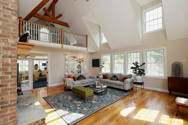 living room featuring baseboards, a high ceiling, and wood finished floors