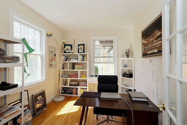 home office with baseboards and wood finished floors