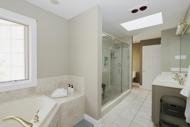 bathroom featuring tile patterned floors, a bath, a healthy amount of sunlight, and a skylight
