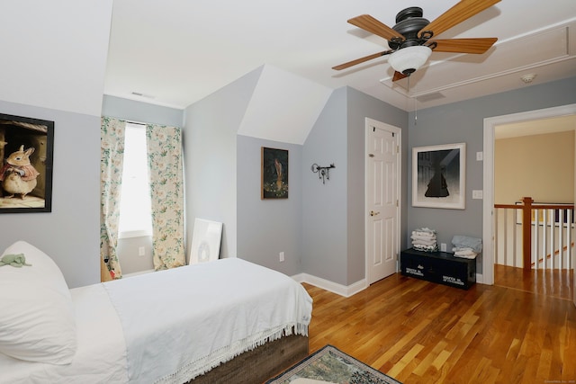 bedroom featuring ceiling fan, attic access, visible vents, wood finished floors, and baseboards