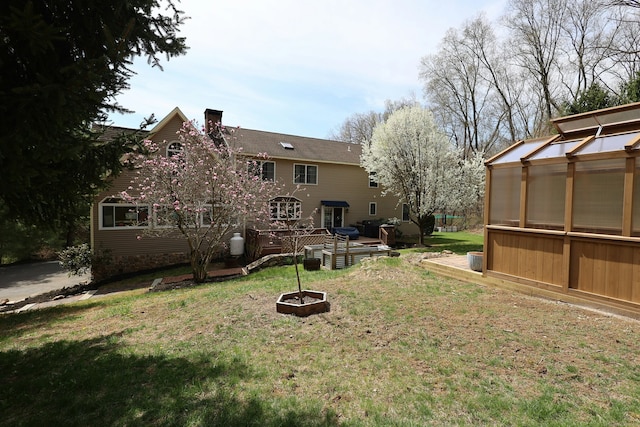 view of yard featuring an outdoor structure, a greenhouse, and a deck