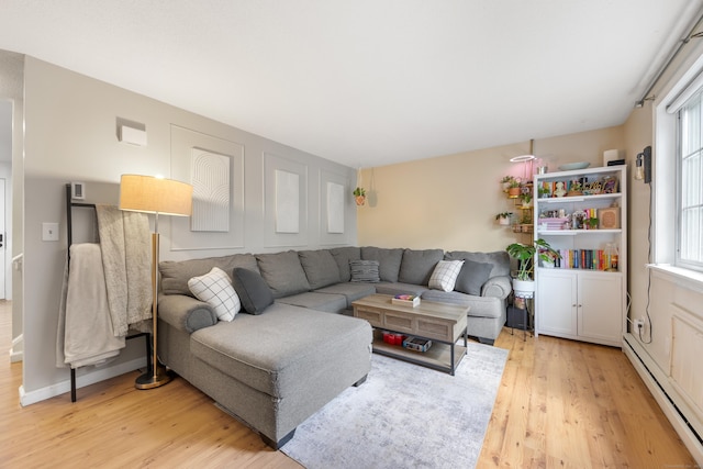 living room featuring baseboard heating and light wood-style flooring