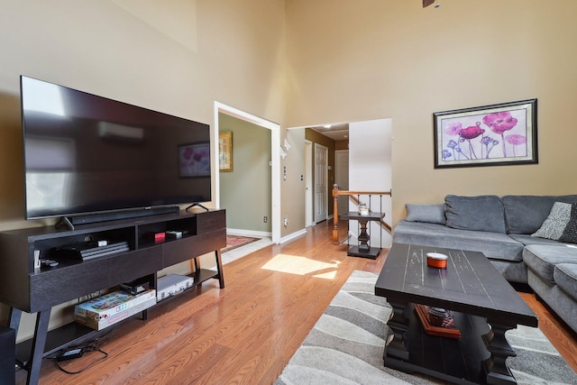 46 Fairway Grn, Fairfield, CT 06825 - living room with a towering ceiling, wood finished floors, and baseboards