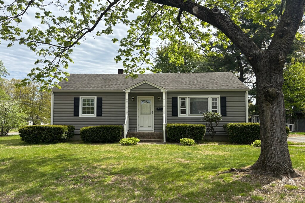 view of front of property with a shingled roof and a front yard