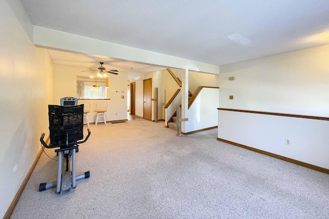 living area with stairway, baseboards, a ceiling fan, and carpet flooring