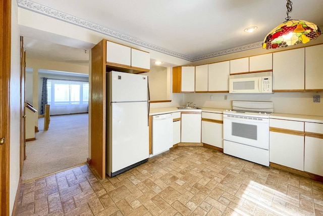 kitchen featuring white appliances, brick patterned floor, a sink, and light countertops