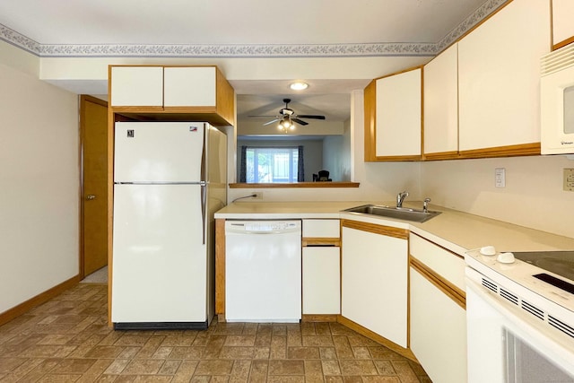 kitchen featuring ceiling fan, a sink, white appliances, light countertops, and baseboards