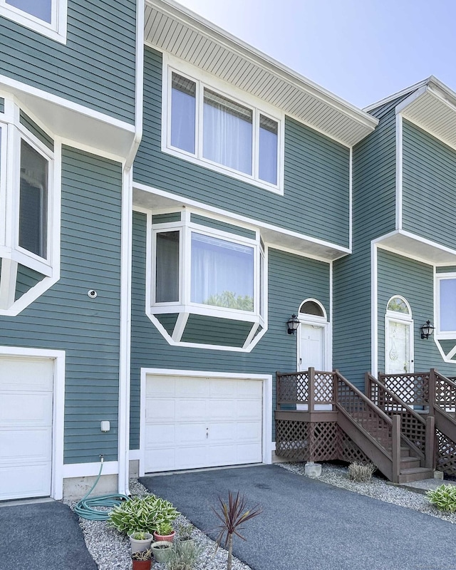raised beach house featuring a garage and aphalt driveway