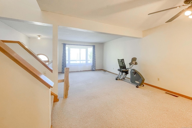 workout area with baseboards, ceiling fan, and carpet