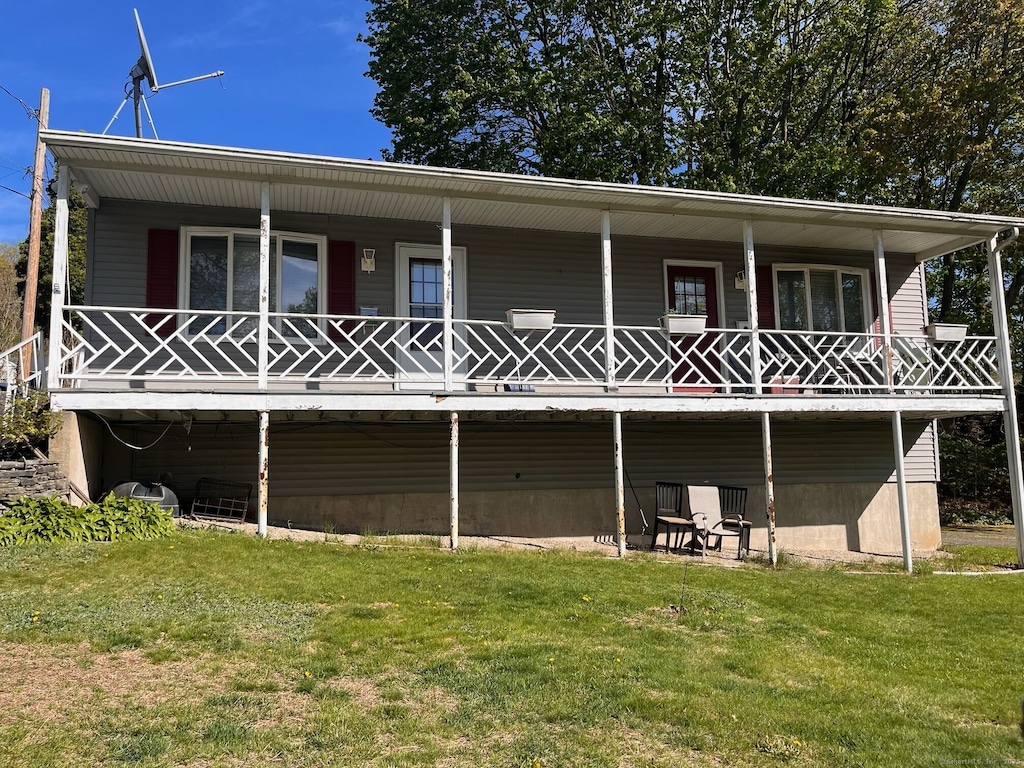 back of house featuring a yard and a porch