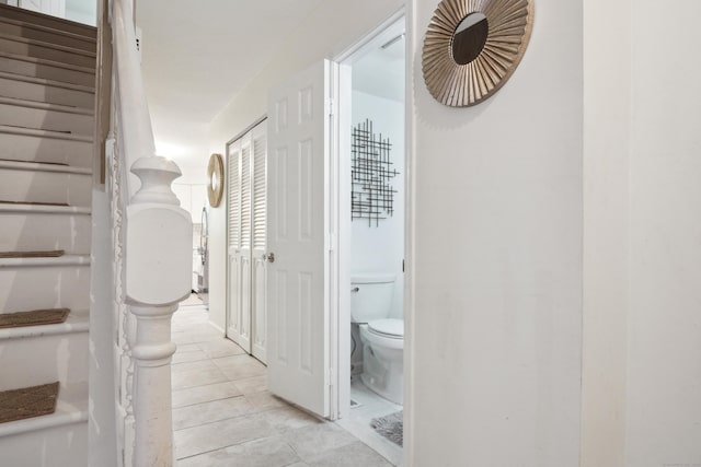 hall with stairway and light tile patterned floors