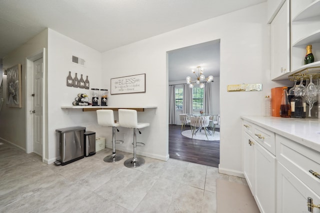 bar with baseboards, a dry bar, light tile patterned flooring, and visible vents