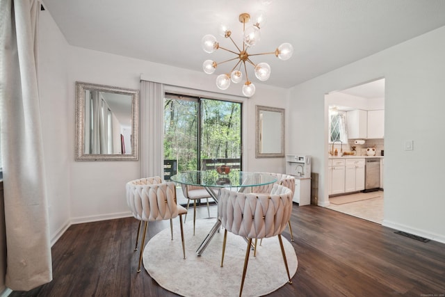 dining space featuring baseboards, a chandelier, wood finished floors, and visible vents