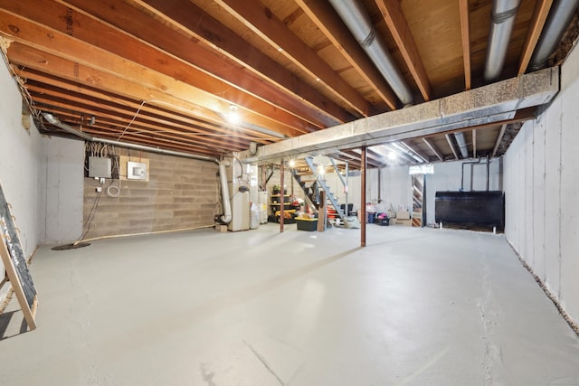 unfinished below grade area featuring stairs, heating unit, and heating fuel