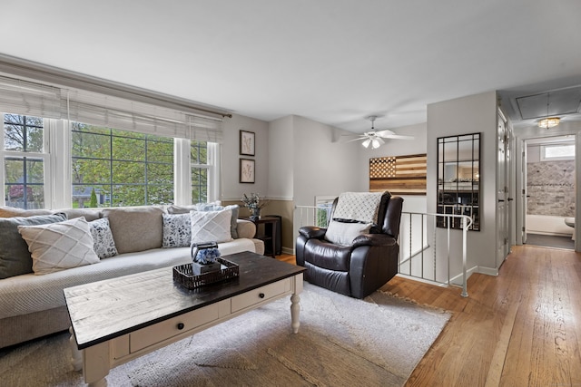living area featuring ceiling fan, hardwood / wood-style flooring, attic access, and baseboards
