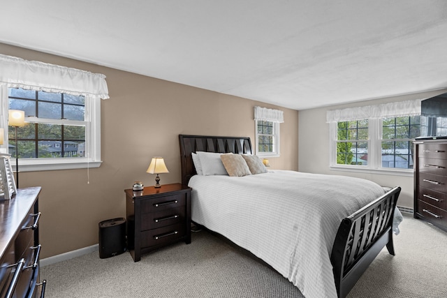 bedroom featuring light colored carpet and baseboards