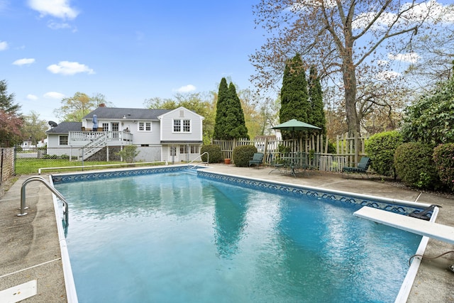 view of swimming pool with fence, a patio, stairway, a diving board, and a fenced in pool