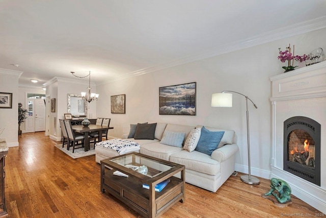44 Woodcrest Ln Unit 44, Danbury, CT 06810 - living room featuring a lit fireplace, light wood-type flooring, a chandelier, and crown molding