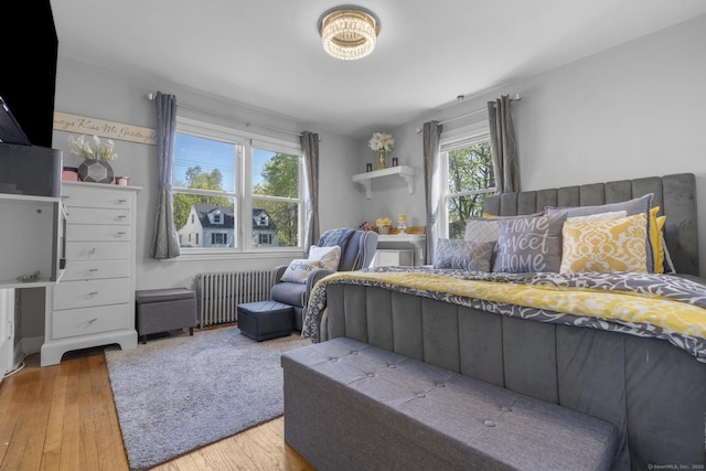 bedroom with radiator heating unit and hardwood / wood-style floors