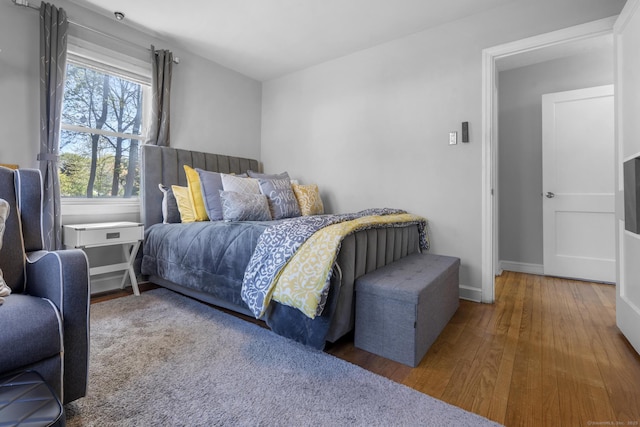 bedroom with baseboards and wood finished floors