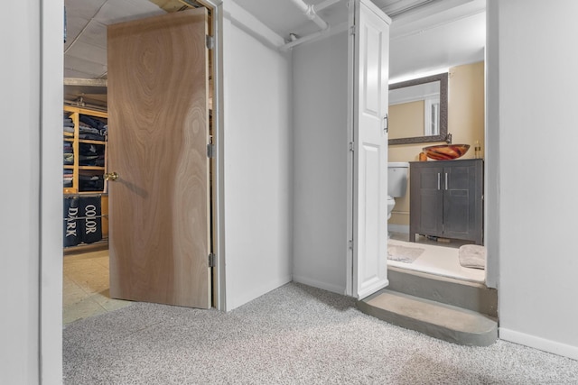 bathroom featuring toilet, baseboards, and a sink
